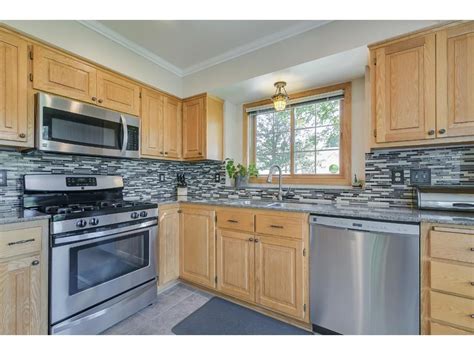 stainless steel appliances with oak cabinets and tile countertops|grey countertops with oak cabinet.